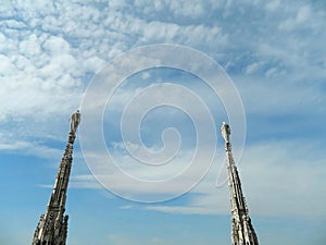 Cloudy sky over the Milan Duomo and it's two spires with statues