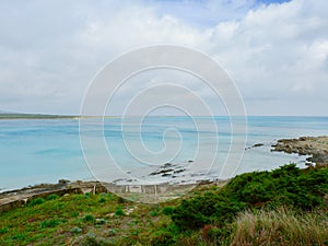 Cloudy sky over picturesque beach of Stintino, on north part of Sardinia, Italy. Shoreline with turquoise water on La Pelosa beach