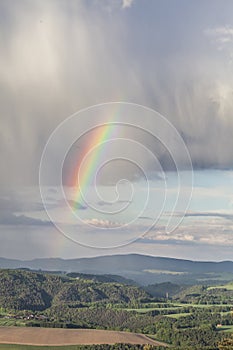 Cloudy sky with a rainbow in bright colors