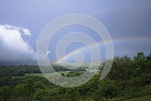 Cloudy sky and rainbow, Jura mountains, France