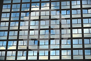 Cloudy sky reflection on glass surface of modern building