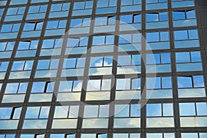 Cloudy sky reflection on glass surface of modern building