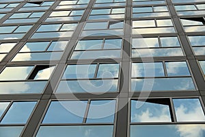 Cloudy sky reflection on glass surface of modern building