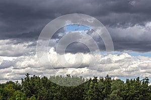 Cloudy sky with storm clouds over the treetops