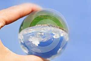 cloudy sky which is reflected in a Lens Ball.Horizon, green field. the world is upside down, on the contrary. new reality, new