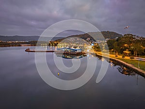 Cloudy sunrise waterscape over Gosford Waterfront and Drifters Wharf with reflections