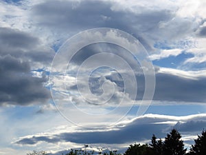 Cloudy sunset. Grey clouds in the blue sky. Stormy, cloudy, rainy, gloomy weather forecast concept.