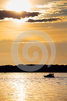 Cloudy sunset with silhouette of lonely boat