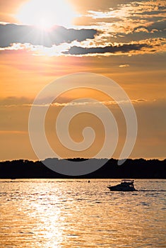 Cloudy sunset with silhouette of lonely boat