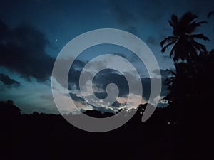 Cloudy sunset sky and dark environment in the evening .