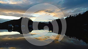 Cloudy sunset sky over the calm Loch Lomond, Scotland in autumn