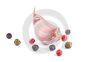 Clove of garlic with peppercorn on white background