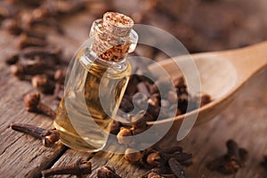Clove oil in a bottle close-up on the table, rustic