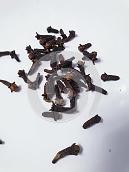 Clove seeds scattered in a white background photo