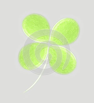 Clover leaves of a liquid green gel with bubbles on grey background