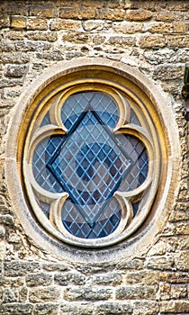 Cloverleaf ancient diamond leaded window in rustic brick building