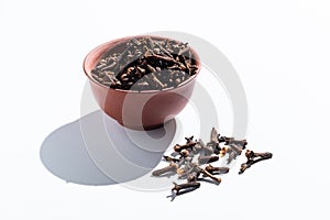 cloves in a clay cup. spice on white