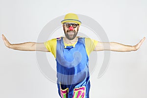A clown in a bright suit stretched out his arms in different directions