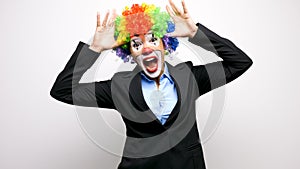 Clown in business suit making silly faces