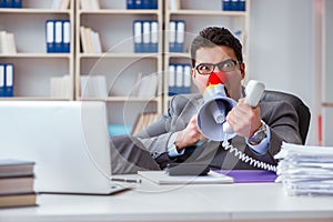The clown businessman angry in the office with a megaphone
