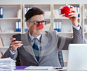 Clown businessman with piggy bank doing accounting