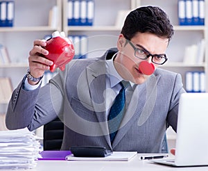 Clown businessman with piggy bank doing accounting