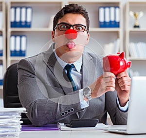 Clown businessman with piggy bank doing accounting