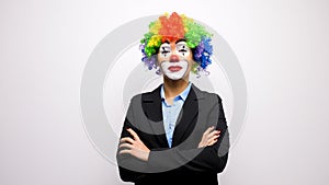 Clown with a colorful wig in business suit