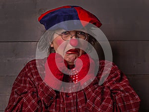 Clown with grimace annoyance, red nose clothes, beret