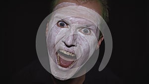 Clown Halloween man portrait. Close-up of an evil clowns face. White face makeup