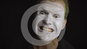 Clown Halloween man portrait. Close-up of an evil clowns face. White face makeup