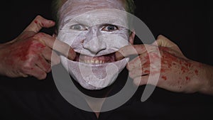 Clown Halloween man portrait. Close-up of an evil clowns face. White face makeup