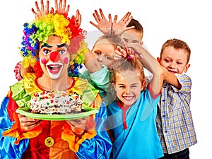 Clown holding cake on birthday with group children