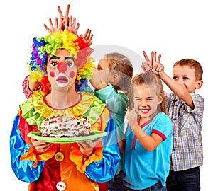 Clown holding cake on birthday with group children