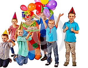 Clown holding cake on birthday with group children.