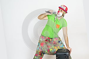 The clown is holding a microphone, singing. There is a column next to it. Isolated on white