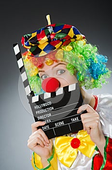 The clown with movie clapper in funny concept