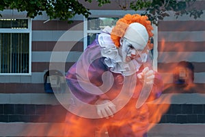 Clown with sharp teeth on fire on a urban background with payphones .. Halloween or cosplay for All Saints Day. The concept of