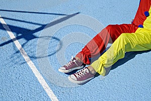 Clown sitting on an outdoor basketball court