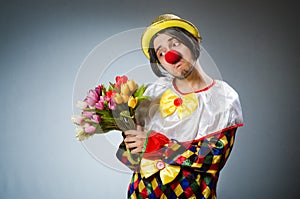 The clown with tulip flowers in funny concept