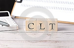 CLT word on a wooden block with clipboard and calcuator