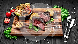 Club Beef steak with pepper sauce and Grilled vegetables on cutting board