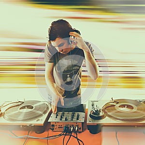 Club DJ playing mixing music on vinyl turntable