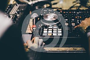 Club DJ playing mixing music on vinyl turntable at party