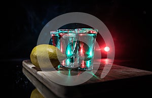 Club drink concept. Tasty alcohol drink cocktail tequila with lime and salt on vibrant dark background or glasses with tequila at