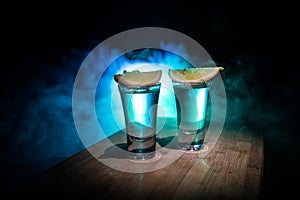 Club drink concept. Tasty alcohol drink cocktail tequila with lime and salt on vibrant dark background or glasses with tequila at