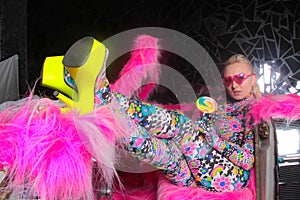 Club party blonde girl in acid anime style spandex catsuit with mirror car with pink fur ready for crazy clubbing life