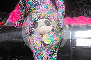 Club party blonde girl in acid anime style spandex catsuit with mirror car with pink fur ready for crazy clubbing life
