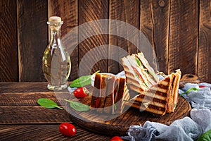 Club sandwich with ham, tomato, cheese and spinach. Grilled panini