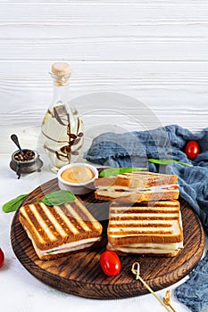 Club sandwich with ham, tomato, cheese and spinach. Grilled panini